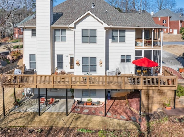 back of house featuring a wooden deck and a patio