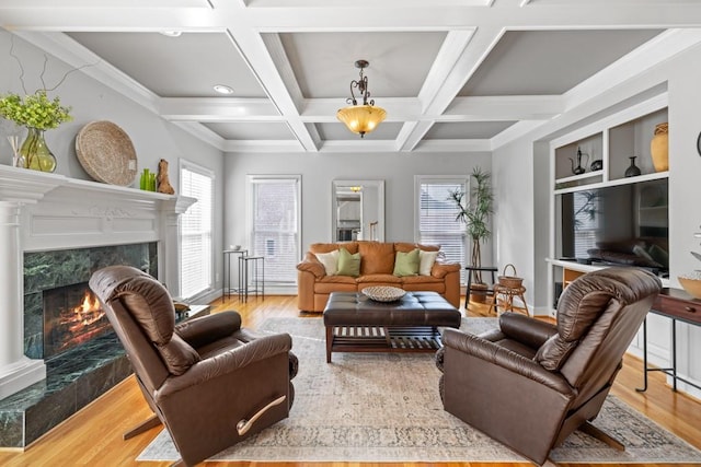 living room featuring beamed ceiling, wood-type flooring, coffered ceiling, and a fireplace