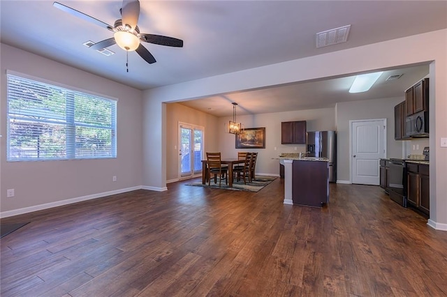 kitchen featuring pendant lighting, ceiling fan with notable chandelier, stainless steel appliances, and dark hardwood / wood-style floors