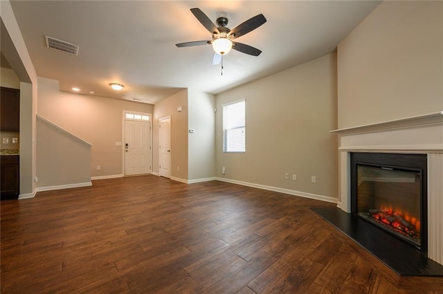 unfurnished living room featuring ceiling fan and dark hardwood / wood-style floors