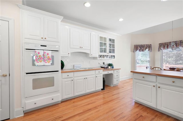 kitchen featuring white appliances, light wood-type flooring, and white cabinets