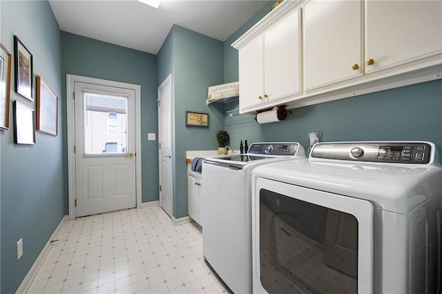 washroom featuring cabinet space, washing machine and dryer, baseboards, and light floors