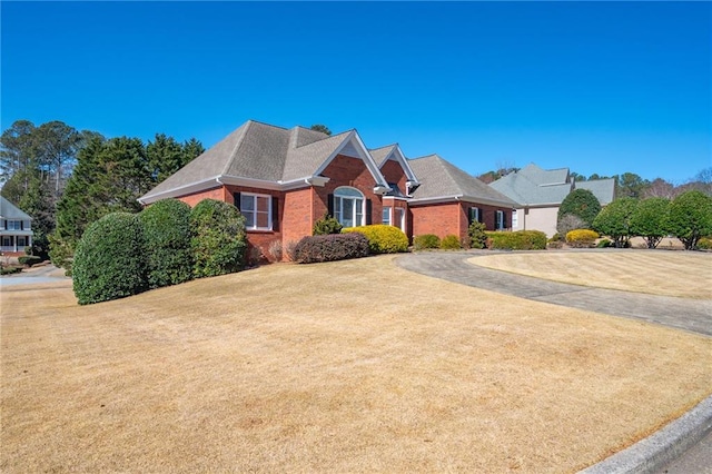 view of front facade featuring brick siding and a front lawn