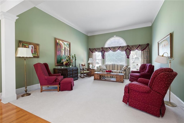 living area featuring wood finished floors, carpet flooring, baseboards, decorative columns, and crown molding