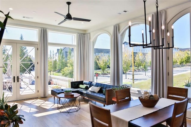 sunroom / solarium with french doors and ceiling fan with notable chandelier