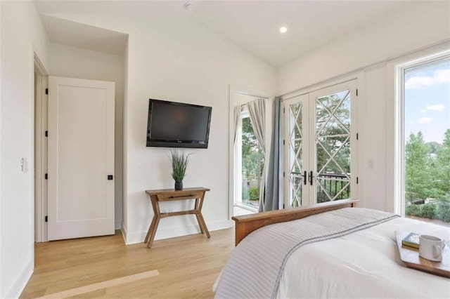 bedroom with vaulted ceiling, access to exterior, light hardwood / wood-style floors, and french doors