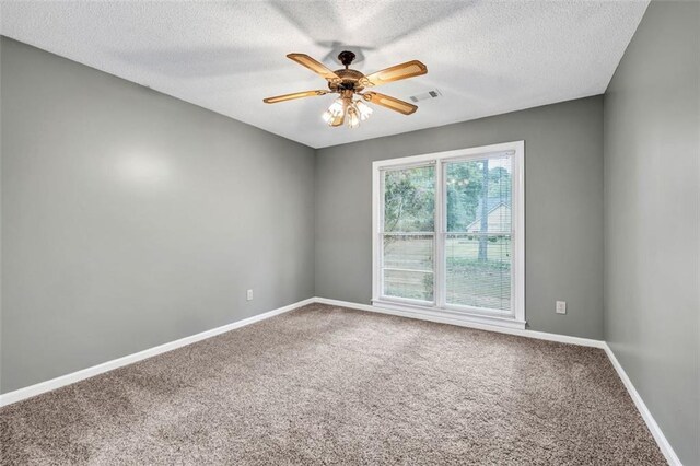 empty room with carpet floors, ceiling fan, and a textured ceiling