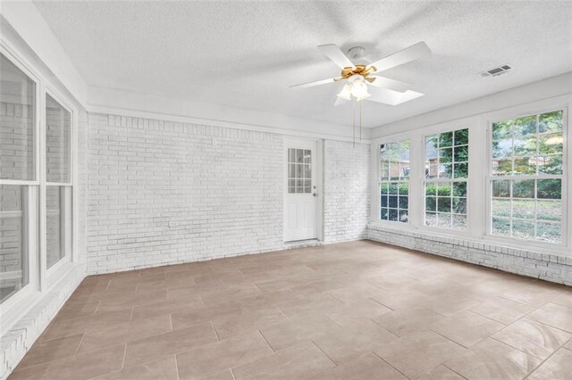 unfurnished sunroom featuring a skylight and ceiling fan