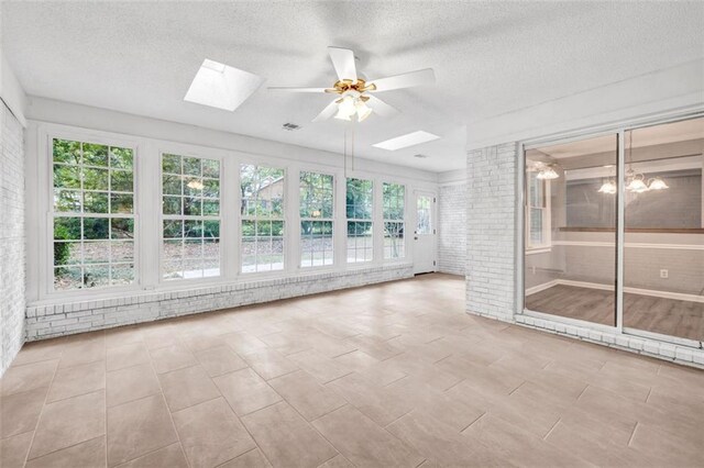 unfurnished sunroom with a skylight and ceiling fan