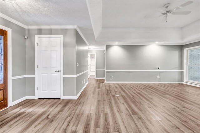 spare room with ceiling fan, light hardwood / wood-style floors, ornamental molding, and a textured ceiling