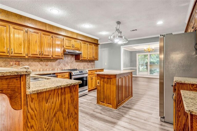 kitchen featuring light wood-type flooring, pendant lighting, crown molding, stainless steel appliances, and a center island