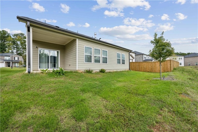 rear view of property with a lawn