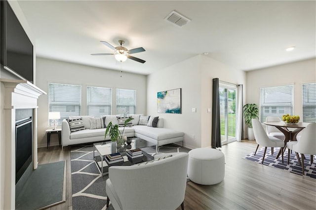 living room with dark hardwood / wood-style flooring and ceiling fan