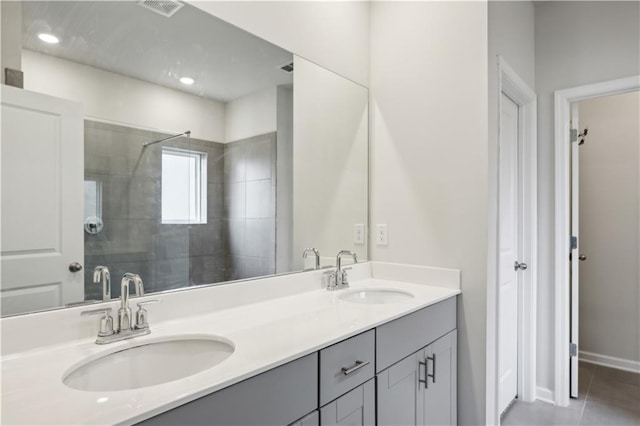 bathroom with tile patterned floors, a shower with door, and vanity