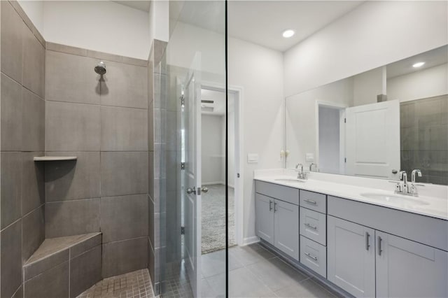 bathroom featuring a tile shower, tile patterned floors, and vanity