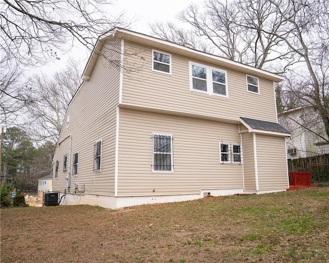 rear view of house with a yard and central AC