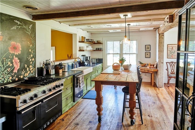 kitchen with sink, green cabinetry, appliances with stainless steel finishes, pendant lighting, and beam ceiling