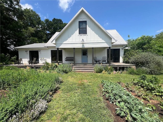 back of property featuring a lawn and a porch