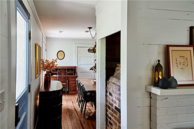 corridor featuring brick wall and hardwood / wood-style floors