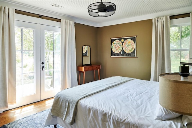 bedroom featuring hardwood / wood-style flooring, ornamental molding, access to exterior, and french doors