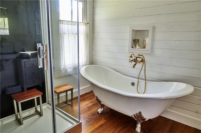 bathroom with hardwood / wood-style floors, plenty of natural light, and a washtub