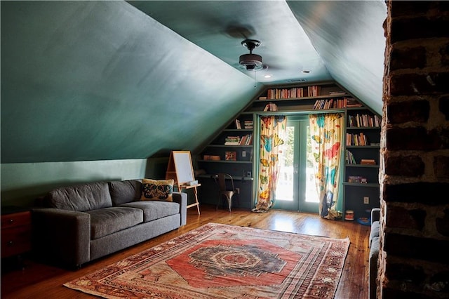 additional living space featuring vaulted ceiling, hardwood / wood-style floors, and built in shelves