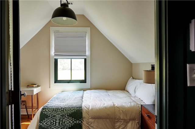 bedroom featuring baseboard heating, lofted ceiling, and hardwood / wood-style flooring