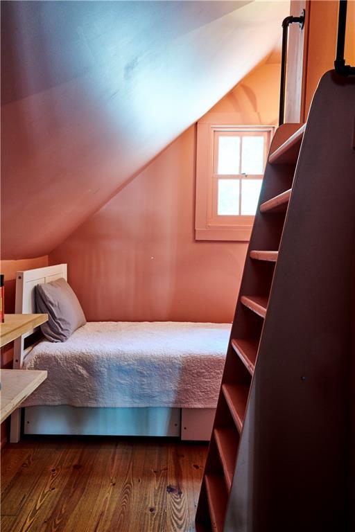 bedroom featuring lofted ceiling and wood-type flooring