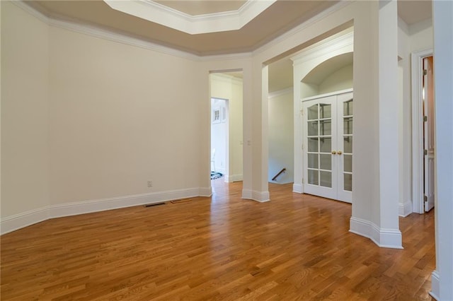 unfurnished room featuring hardwood / wood-style flooring, ornamental molding, and french doors