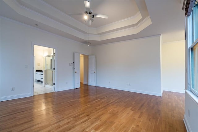 unfurnished bedroom with light hardwood / wood-style flooring, ornamental molding, a raised ceiling, and ceiling fan