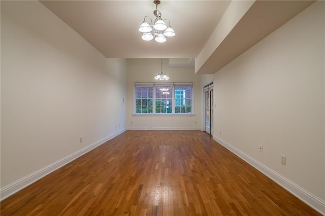 unfurnished dining area with hardwood / wood-style flooring and a notable chandelier