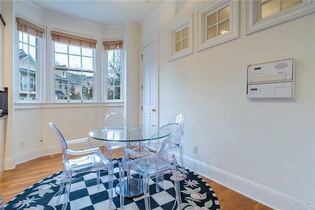 dining area with hardwood / wood-style floors and crown molding