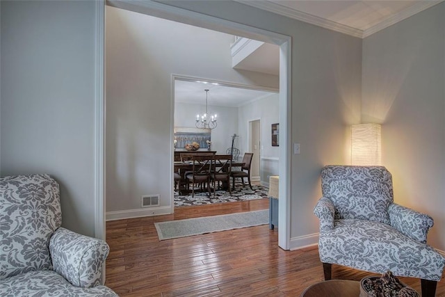 sitting room with crown molding, a notable chandelier, and dark hardwood / wood-style flooring