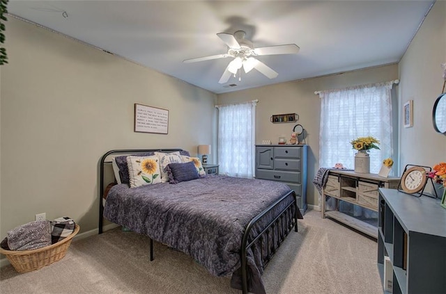 carpeted bedroom with ceiling fan and multiple windows