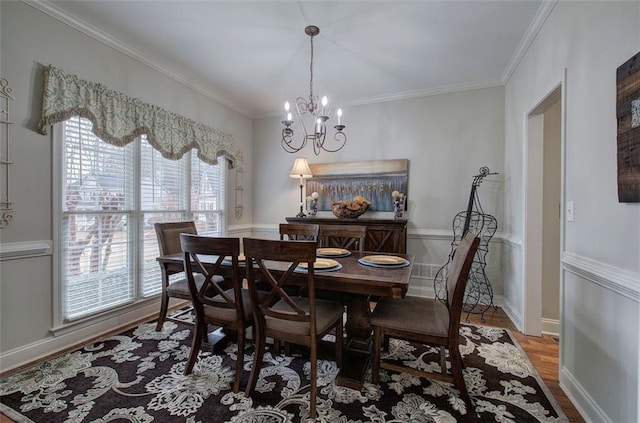 dining room featuring hardwood / wood-style flooring, crown molding, and an inviting chandelier