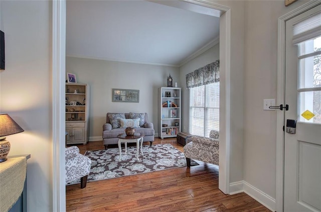 living area with wood-type flooring and ornamental molding