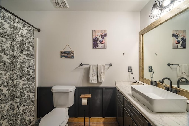 bathroom featuring curtained shower, vanity, and toilet