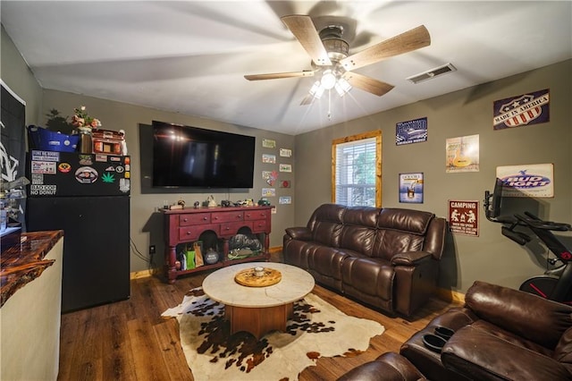 living room featuring ceiling fan and dark hardwood / wood-style flooring