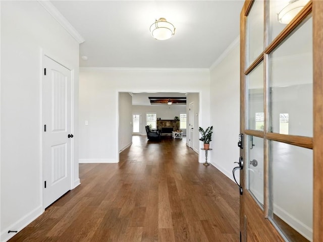 hall featuring baseboards, dark wood-type flooring, and crown molding