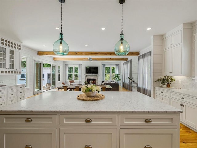 kitchen featuring recessed lighting, open floor plan, light stone counters, and tasteful backsplash