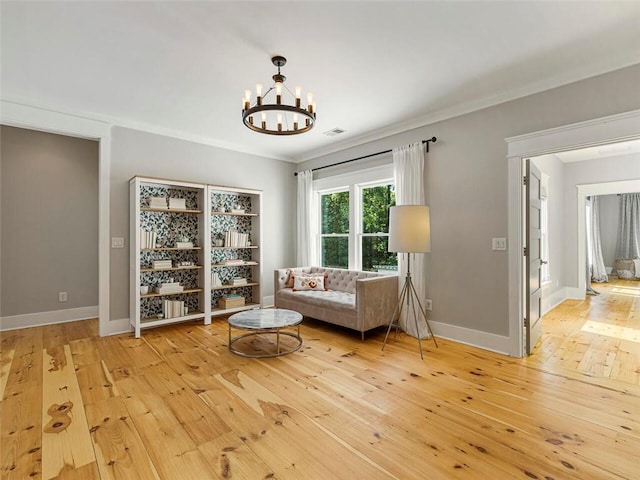 sitting room featuring wood-type flooring, baseboards, an inviting chandelier, and visible vents