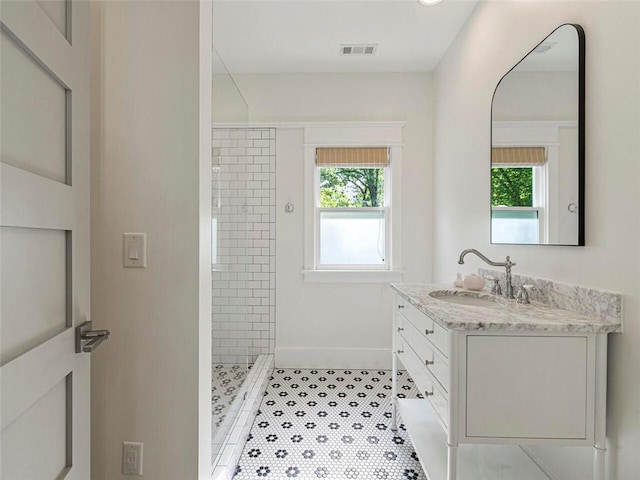 full bathroom with vanity, visible vents, a shower stall, and plenty of natural light
