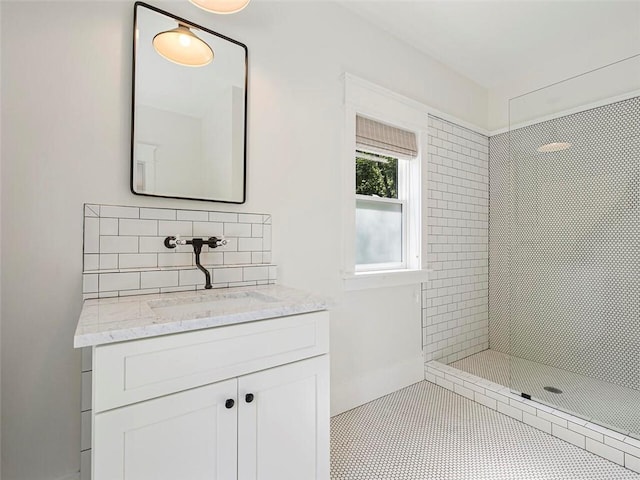 bathroom with vanity, backsplash, and tiled shower