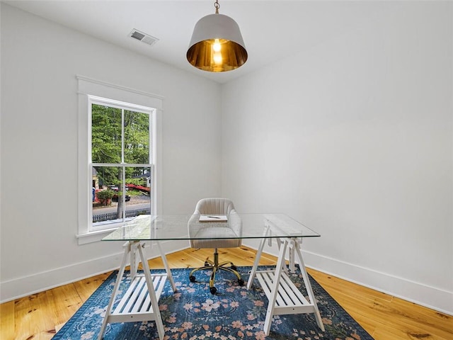 office area with baseboards, wood finished floors, and visible vents