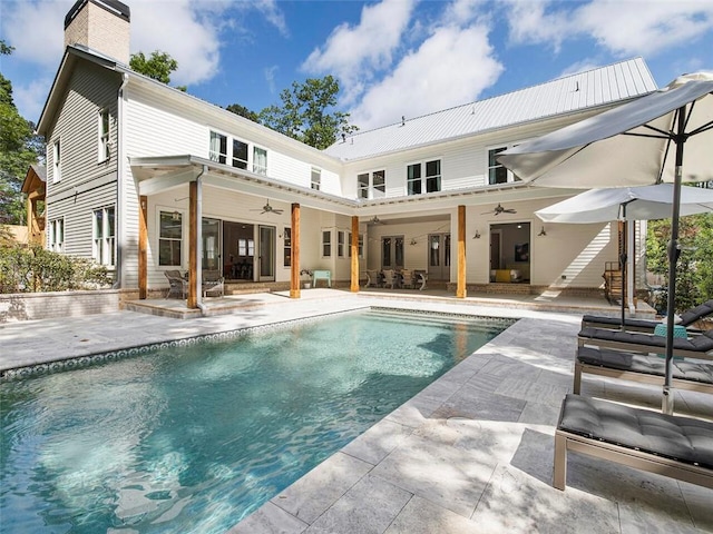 back of house with a patio, ceiling fan, a chimney, and an outdoor pool