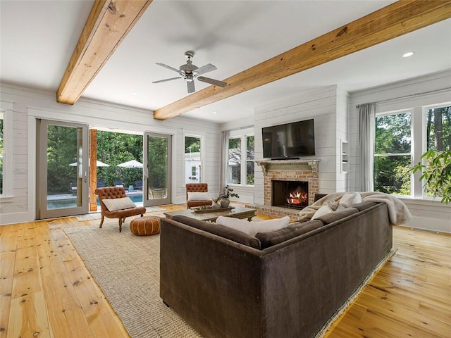 living area featuring light wood-type flooring, a wealth of natural light, and a fireplace