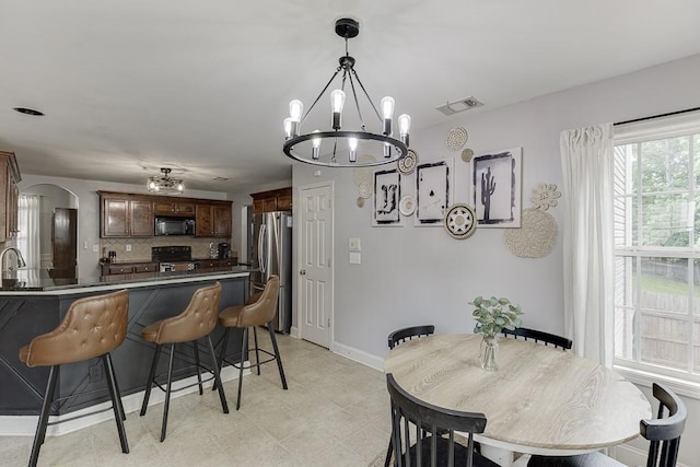 1751 Fire Side Ct, Jefferson, GA 30549 - dining area featuring a chandelier, arched walkways, and light flooring