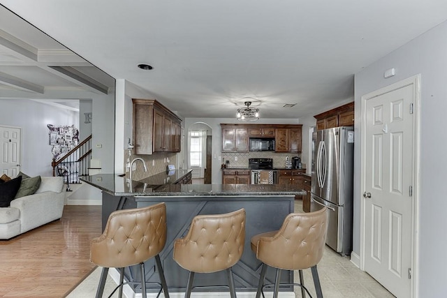 1751 Fire Side Ct, Jefferson, GA 30549 - kitchen featuring freestanding refrigerator, black microwave, range, a peninsula, and decorative backsplash