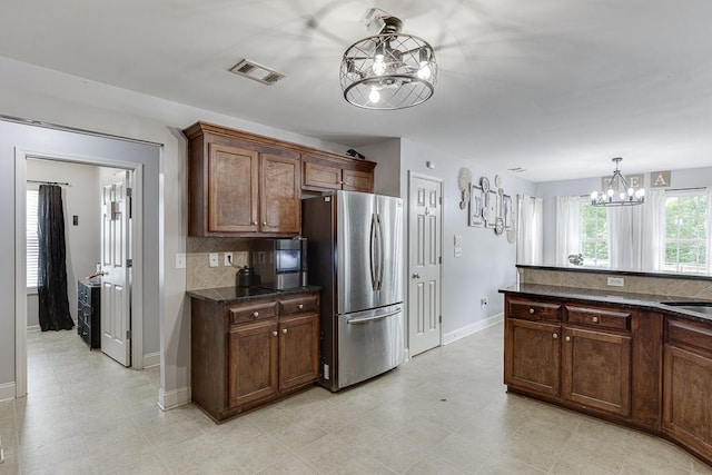 1751 Fire Side Ct, Jefferson, GA 30549 - kitchen featuring freestanding refrigerator, a chandelier, decorative backsplash, and pendant lighting