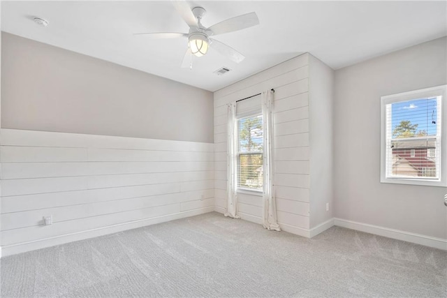 unfurnished room featuring carpet, visible vents, ceiling fan, and baseboards